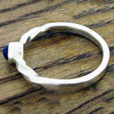 Silver ring with a Lapis gemstone on a wooden surface